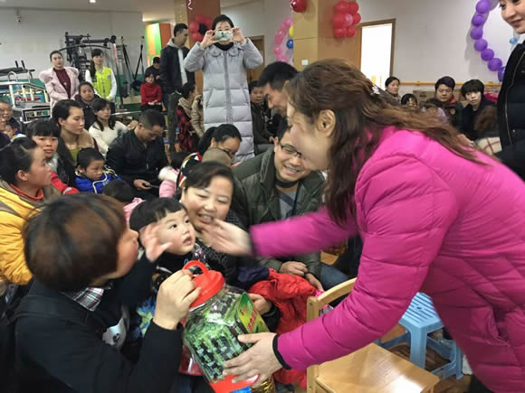 图为：齐晓玲副主任给孩子发慰问品