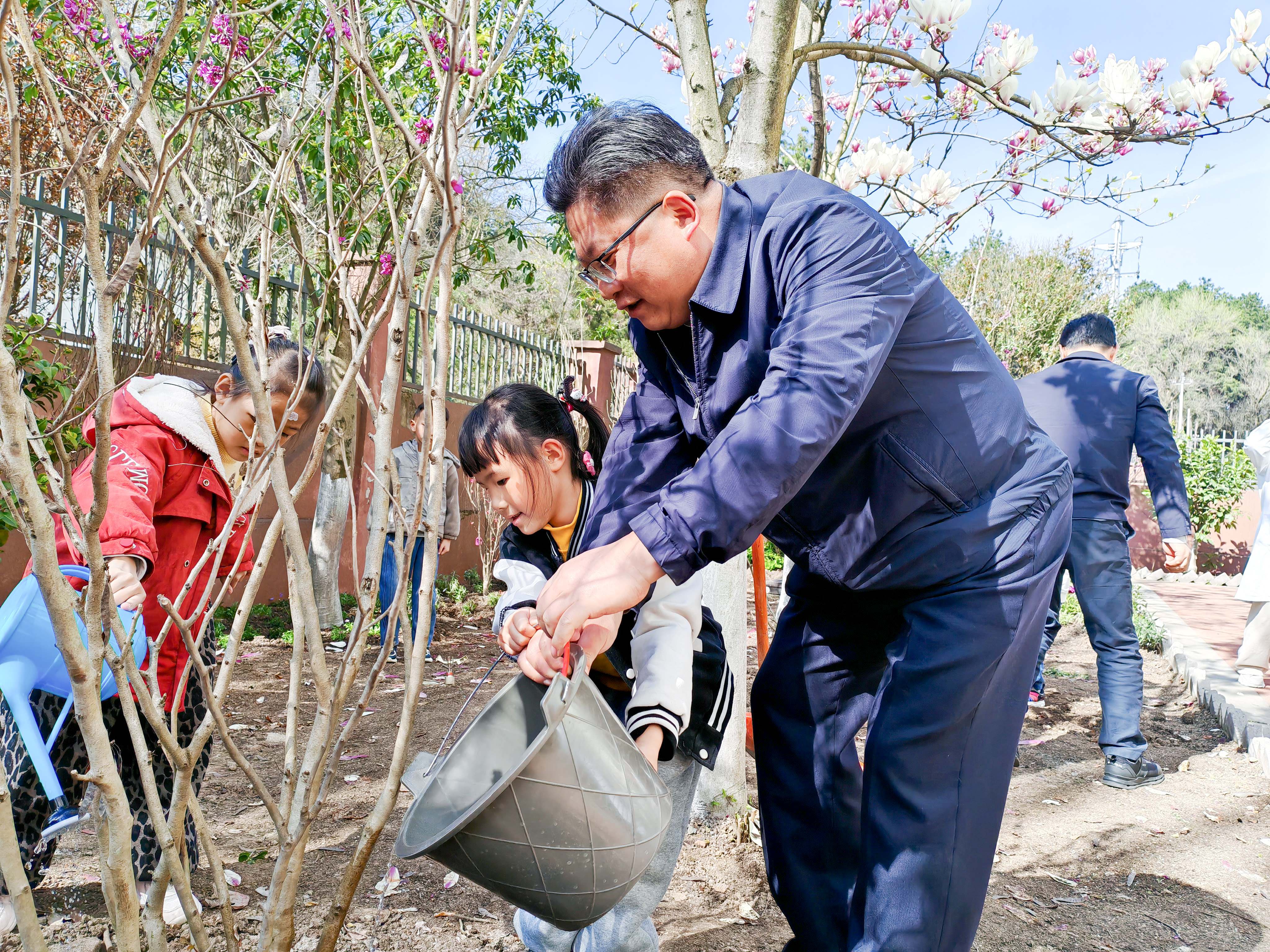 周代军书记与儿童共同浇灌树木.jpg